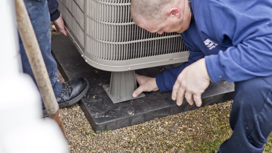 Workers installing A/C unit